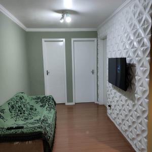 uma sala de estar com um sofá e uma televisão na parede em Apartamento em Teresópolis - RJ em Teresópolis