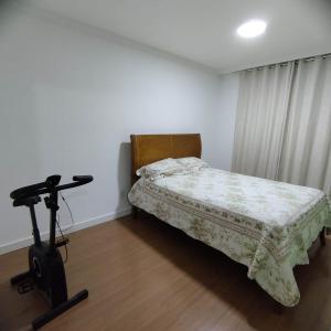 a bedroom with a bed and a vacuum in it at Apartamento em Teresópolis - RJ in Teresópolis