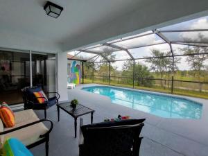 een zwembad in een woonkamer met een patio bij Stay in style near Disney !!!! in Kissimmee