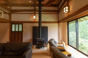 sala de estar con 2 sofás y chimenea en Ryokuinsansou-bettei - Vacation STAY 48641v, en Yasugi
