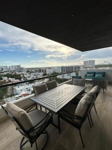 comedor con mesa y sillas en el balcón en Lujoso apartamento, Nuevo! en Cancún