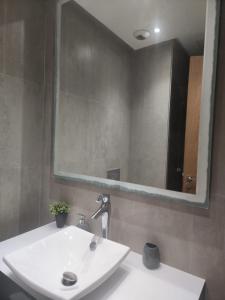 a bathroom with a white sink and a mirror at Appartement de luxe Marina Casablanca in Casablanca