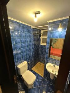 a blue tiled bathroom with a toilet and a sink at Porto Sharm-Elsheikh in Sharm El Sheikh