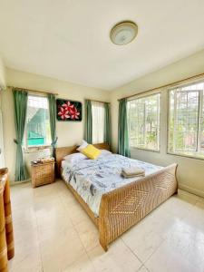 a bedroom with a bed in a room with windows at Flower House Villa in Bogor +16 photos