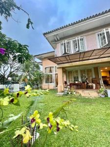 a house with a yard with flowers in front of it at Flower House Villa in Bogor