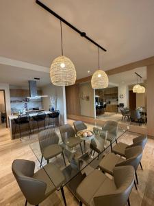 a living room with a glass table and chairs at Lujoso apartamento, Nuevo! in Cancún