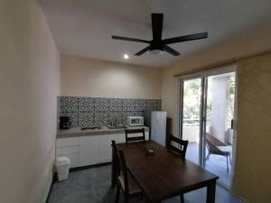 a kitchen with a table and a ceiling fan at Marysol beachfront next to nomads d4 in Isla Mujeres