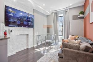 uma sala de estar com um sofá e uma televisão na parede em SWJ 4th and 5th - Save on 2Day+ Stays_Duplex em Nova York