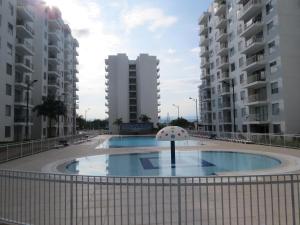 una piscina con sombrilla frente a algunos edificios en Espléndido y Fantástico Apartamento en Girardot. 4 Piscinas, WiFi, Parque infantil, Parqueadero privado. en Girardot