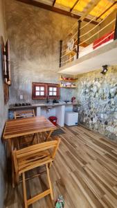 eine Küche mit einem Holztisch und Stühlen im Zimmer in der Unterkunft Pousada Carcará in Fortim