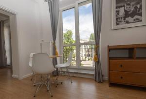 een kamer met 2 stoelen, een bureau en een raam bij Spacious Apt in heart of Warsaw in Warschau