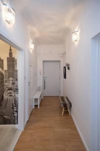 un pasillo con un banco en una habitación blanca en Spacious Apt in heart of Warsaw, en Varsovia