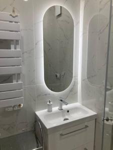 een witte badkamer met een wastafel en een spiegel bij Spacious Apt in heart of Warsaw in Warschau