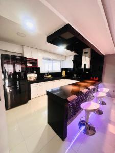 a kitchen with a black counter and stools in it at Departamento La Terraza in Cusco