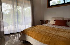 1 dormitorio con cama y ventana grande en Taina Ta, en Hanga Roa