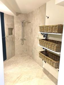 a bathroom with a shower and baskets on the wall at Les Appart villa Sunbay Caraibes avec piscine privative vue mer et montagne in Le François