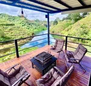 d'une terrasse avec des chaises et une table offrant une vue sur la rivière. dans l'établissement Cabaña Guatapé, à Guatapé