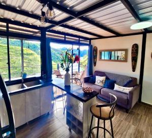 a kitchen and living room with a couch and a table at Cabaña Guatapé in Guatapé