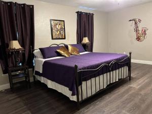 紐奧良的住宿－NEW ORLEANS LADY- POOL TABLE, Pets OK, 4 BDRM，一间卧室配有一张带紫色床单和金色枕头的床。