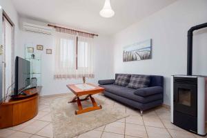 ein Wohnzimmer mit einem Sofa und einem TV in der Unterkunft Apartment in Porec - Istrien 44235 in Poreč