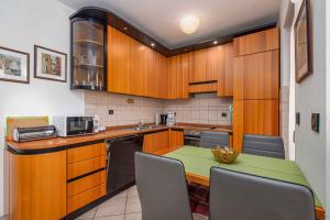 eine Küche mit Holzschränken und einem grünen Tisch in der Unterkunft Apartment in Porec - Istrien 44235 in Poreč