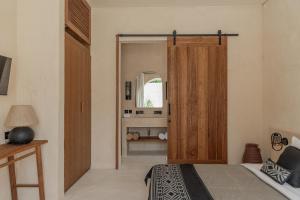 Schlafzimmer mit einem Bett und einer Holztür in der Unterkunft Khaleela Villas in Canggu