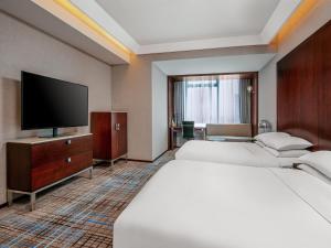 En eller flere senge i et værelse på Renaissance Shanghai Zhongshan Park Hotel