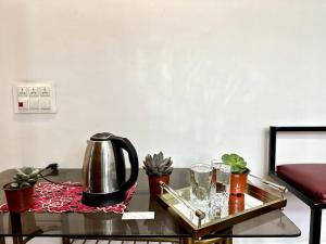 a table with a tea kettle and glasses on it at Syengden Nikunj in Darjeeling