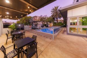 an outdoor patio with tables and a swimming pool at H on Smith Hotel in Darwin