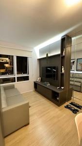 een woonkamer met een bank en een televisie bij Blend Marista in Goiânia
