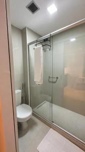 uma casa de banho com um WC e uma cabina de duche em vidro. em Blend Marista em Goiânia