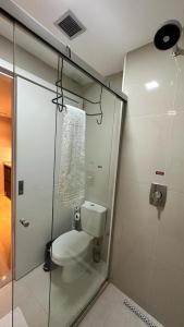 a bathroom with a toilet and a glass shower at Blend Marista in Goiânia