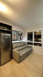uma sala de estar com um sofá e um frigorífico em Blend Marista em Goiânia