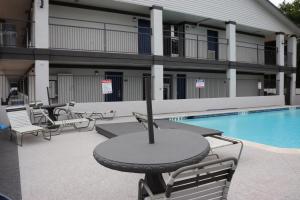 a patio with a table and chairs next to a pool at Motel 6-Alvin, TX in Alvin