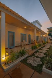 a house with a patio with tables and chairs at Sunnydays homestay in Jepara