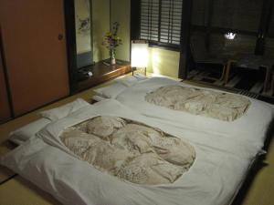 a large white bed with towels on top of it at Yoshii Ryokan in Kurashiki