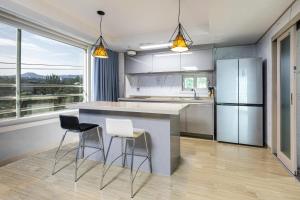 a kitchen with a island with chairs and a counter top at The Bay Jeju Resort in Seogwipo