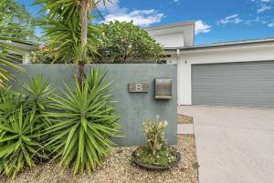 a house with a garage door and some plants at Byron Bay Holiday Homes - Marie and Fred's Villa in Byron Bay
