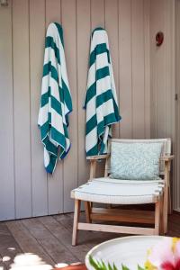 two closed umbrellas and a chair on a patio at Arajilla Retreat in Lord Howe