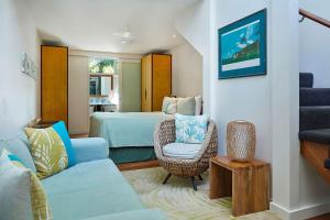 a bedroom with a bed and a couch and a chair at Arajilla Retreat in Lord Howe