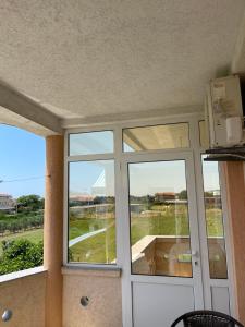 een kamer met 2 grote ramen en een deur bij Apartments Vali in Ulcinj