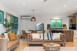 Sala de estar con 2 sofás y mesa en Byron Bay Holiday Homes - Marie and Fred's Villa, en Byron Bay