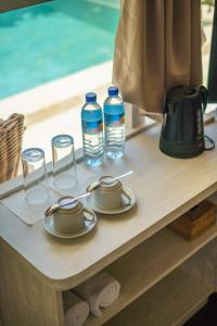 a table with glasses and water bottles on it at Ora Villas Gili Meno in Gili Meno