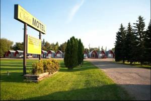um sinal para um motel com casas ao fundo em The little chalet motel em Brandon