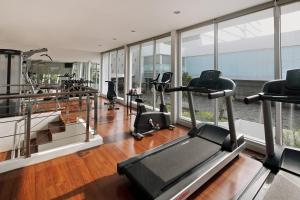 a gym with treadmills and elliptical machines at d'primahotel Tangerang in Tangerang