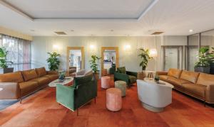 una sala de estar con sofás, mesas y plantas. en H on Smith Hotel, en Darwin