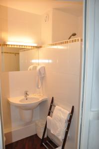 a white bathroom with a sink and a mirror at The Originals City, Hôtel du Château, Pontivy (Inter-Hotel) in Pontivy