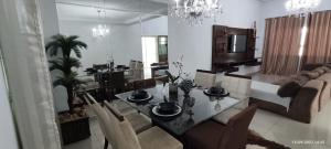 a living room with a dining table and a couch at Residência Cidade Verde 1, sinta-se em casa. in Maringá