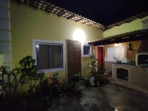 a house with a lit window and a fireplace at Casa amarela 1 quarto in Cabo Frio