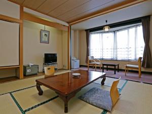 a large living room with a table and chairs at Ashinomaki Prince Hotel in Aizuwakamatsu